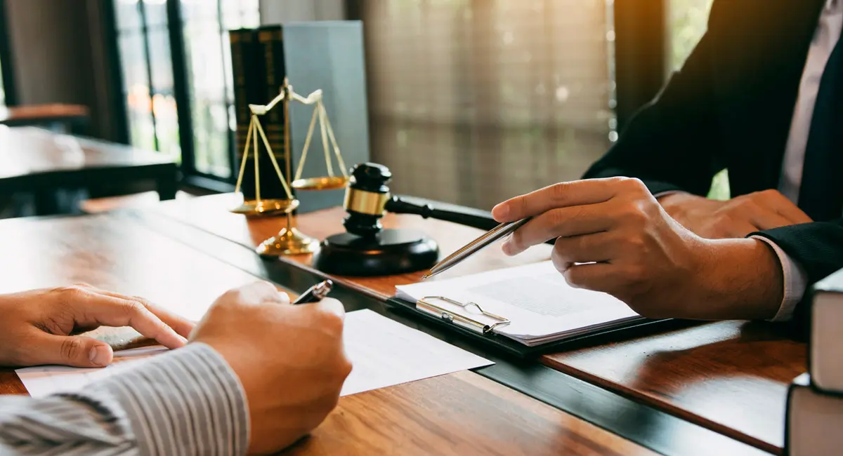 lawyer explaining paperwork to client at desk