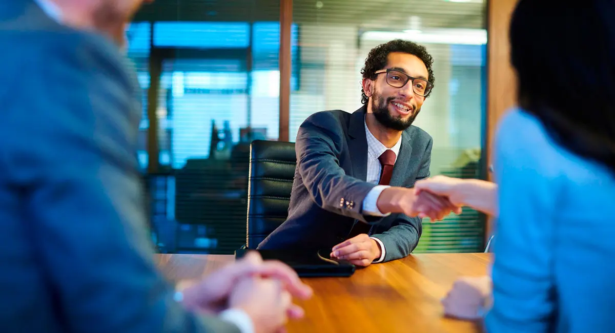 lawyer shaking client's hand at meeting