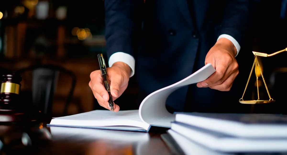lawyer-signing-paperwork-at-desk