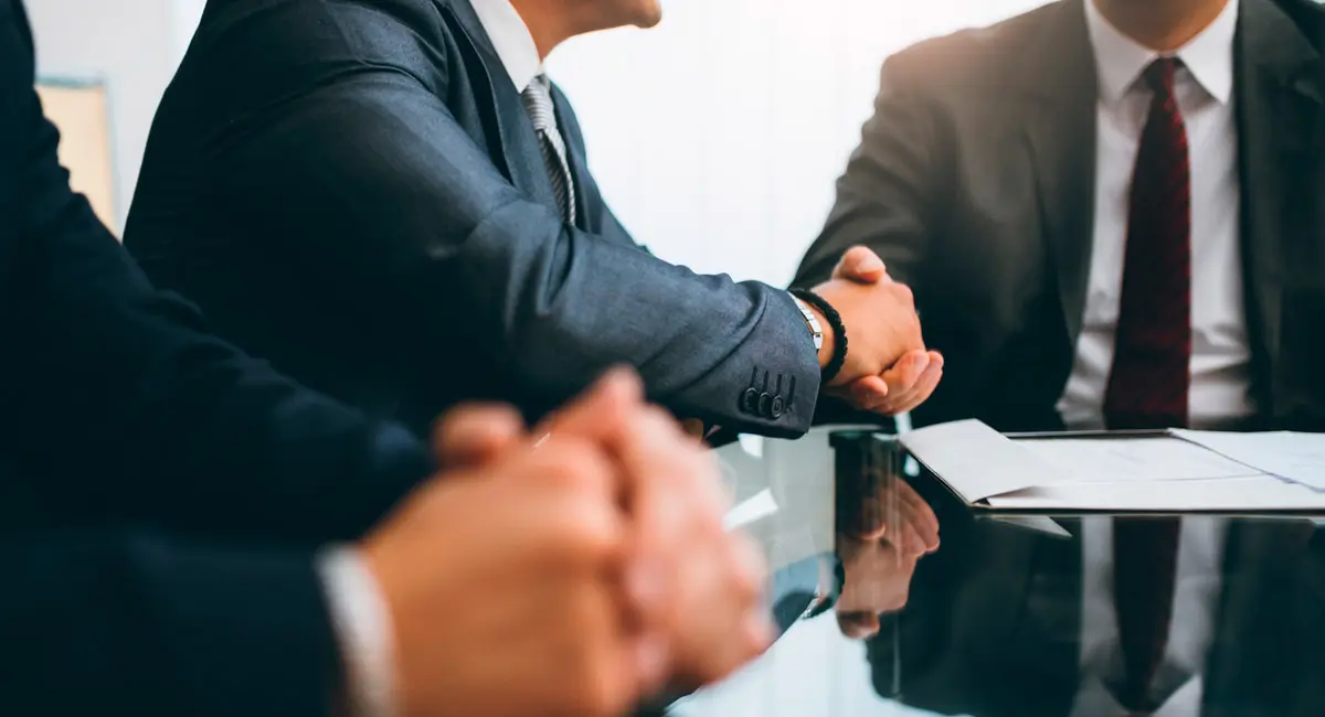 man shaking attorney's hand at conference table