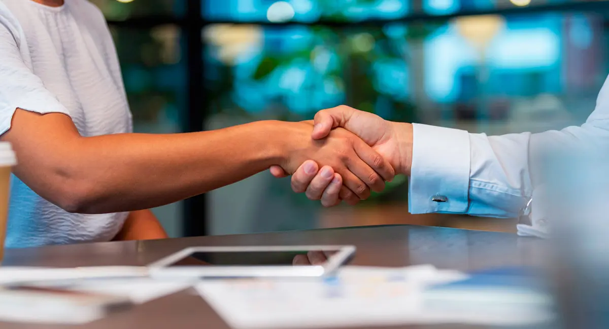 two-people-shaking-hands-over-table