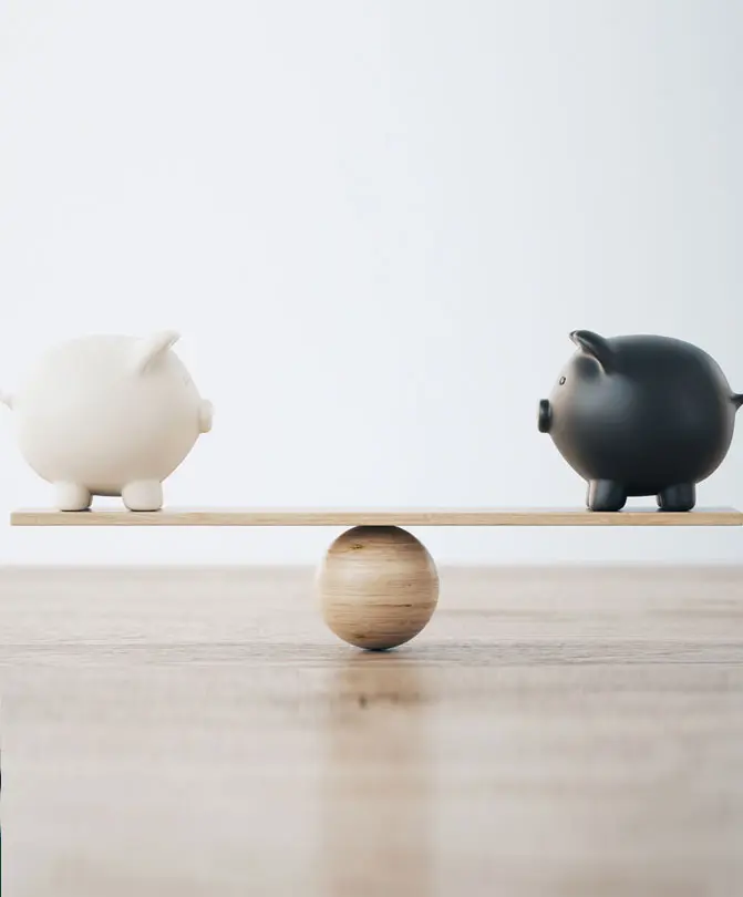 two-piggy-banks-balanced-unevenly-on-a-wooden-plank