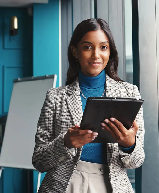 woman-holding-a-tablet-while-standing-in-an-office