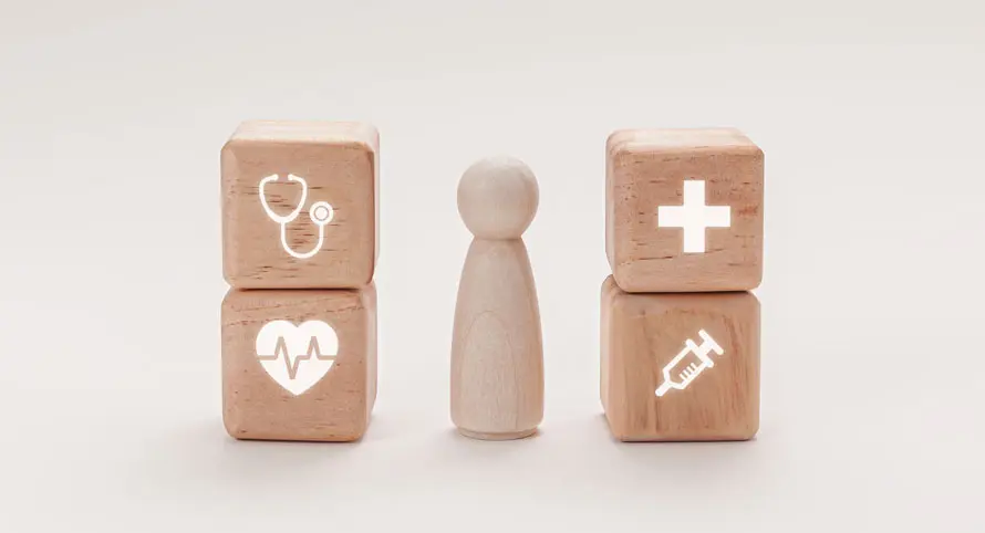wooden-blocks-with-accessibility-and-medical-icons-beside-a-figure