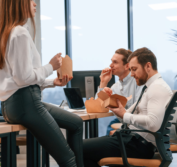 Group-of-coworkers-are-eating-food-from-eco-boxes-in-the-office-together Group-of-coworkers-are-eating-food-from-eco-boxes-in-the-office-together