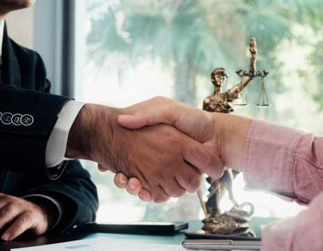 attorney and client shaking hands in office