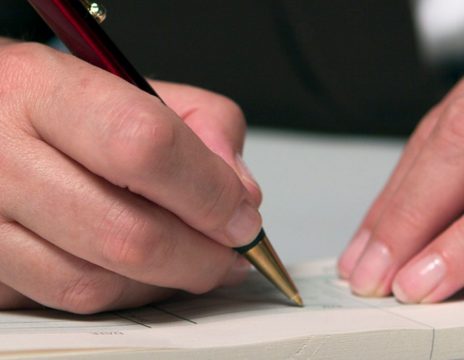 close-up-of-a-person-in-a-suit-signing-a-document