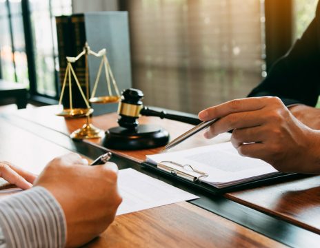 lawyer explaining paperwork to client at desk