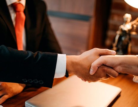 lawyer shaking client's hand at desk