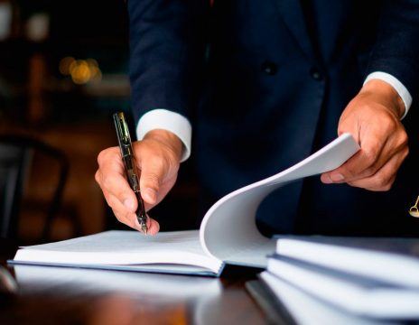 lawyer signing paperwork at desk
