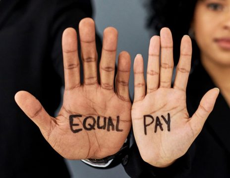 man-and-woman-holding-up-palms-reading-equal-pay