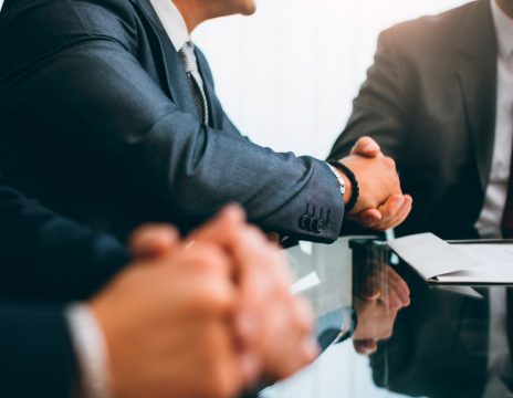 man shaking attorney's hand at conference table