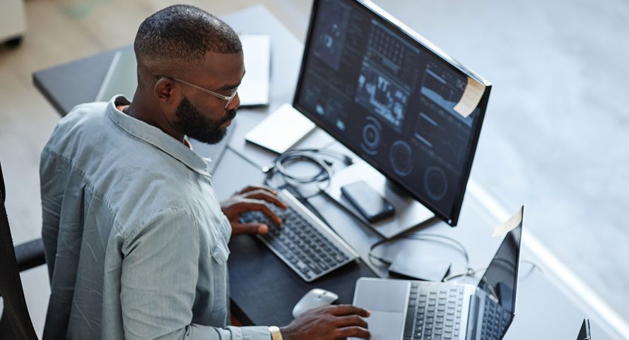 man-working-at-a-desk-with-multiple-monitors