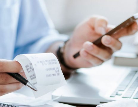 person-reviewing-paperwork-with-a-calculator-and-receipts