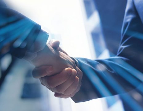 two-people-shaking-hands-in-an-office-setting