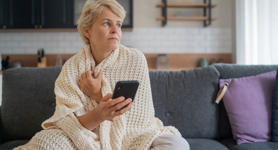 woman-sitting-on-a-couch-looking-at-her-phone